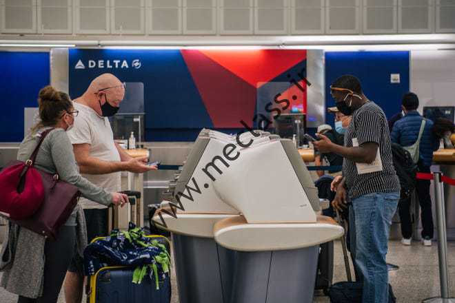 مردم برای پروازهای خروجی در فرودگاه بین قاره ای جورج دبلیو بوش در ژانویه در ایستگاه دلتا چک می کنند.  13، 2022، در هیوستون.